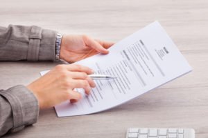 Person holding resume, reading resume, resume parsing, hiring